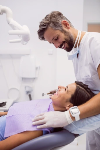 Dentista atendendo paciente com um sorriso